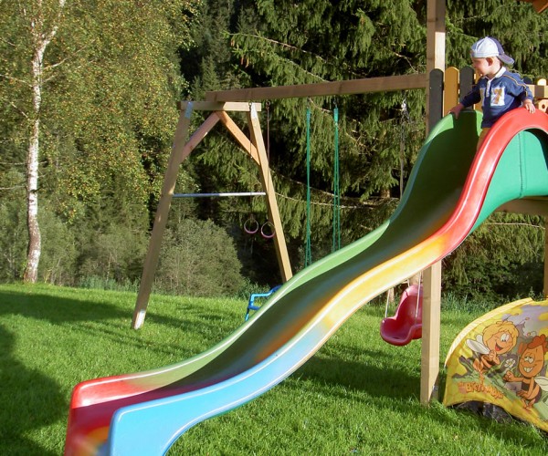 Kind beim Rutschen am Spielplatz